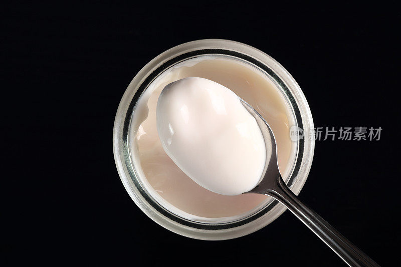 带果酱的酸奶放在带勺子的小玻璃罐中