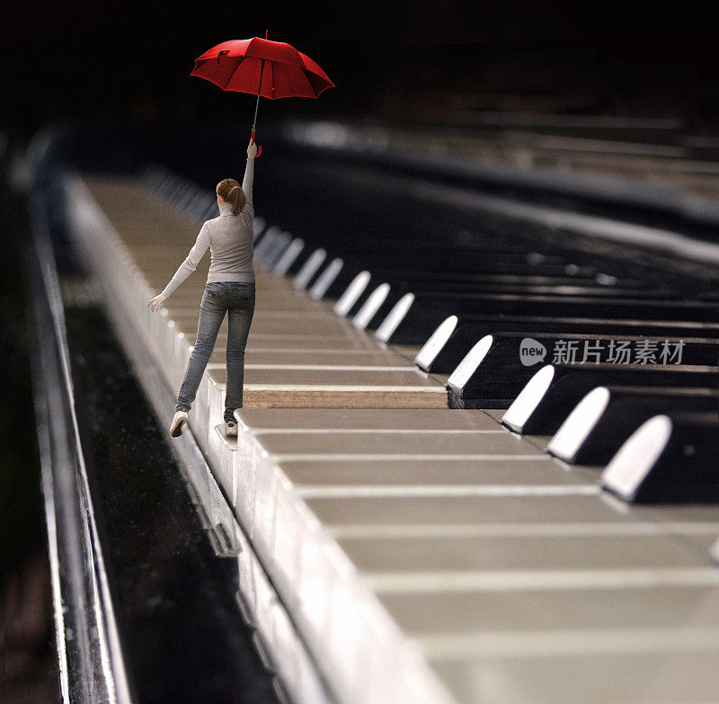 一个女人在钢琴键盘上撑着伞跳着