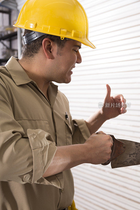 建筑安全:工人在锯东西时切到拇指。