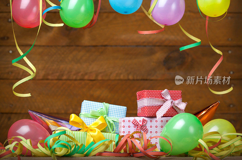 生日派对:礼物-气球和彩带，木制背景