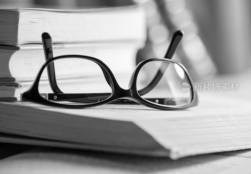 黑白图片上的一本书眼镜
