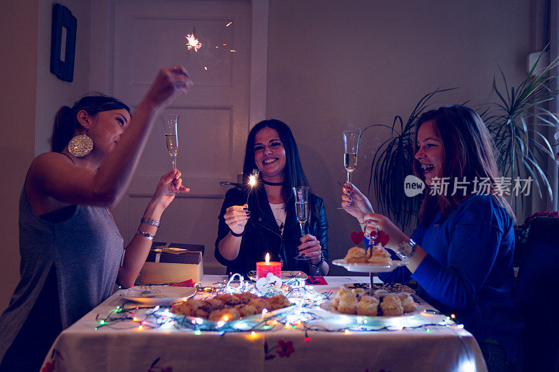 三个女孩在生日派对上点蜡烛