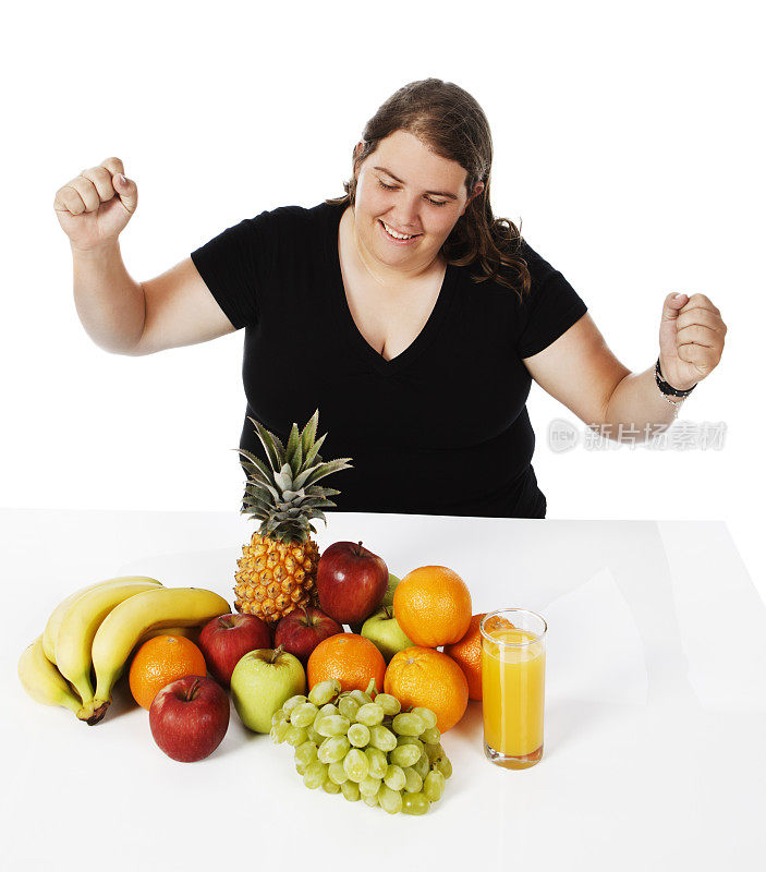 超重的年轻女子看着她的健康水果选择很高兴
