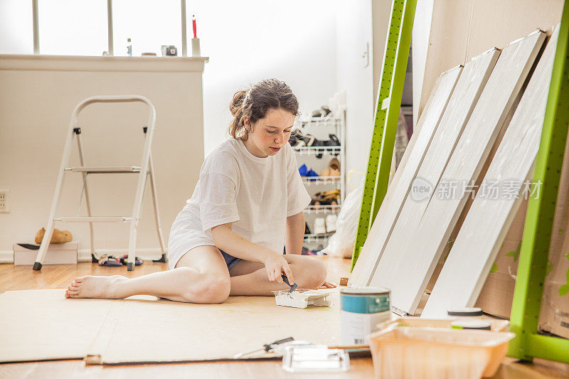 十几岁的女孩油漆家具细节的手段，一个滚轴