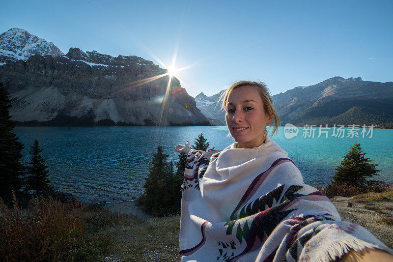 年轻女子与壮观的湖和山风景自拍