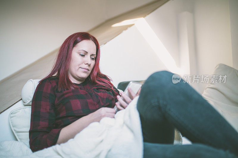 轻松的女人在家里看短信