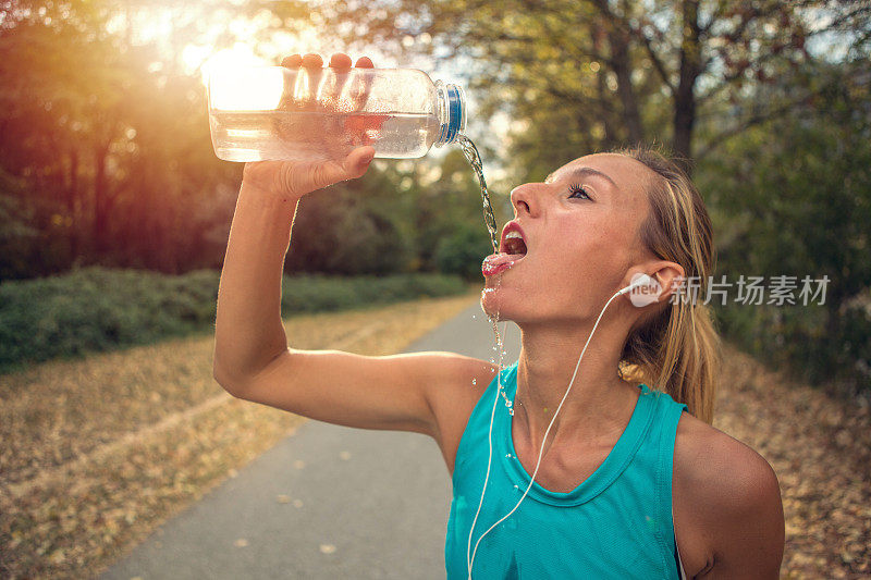 女跑步者用水瓶喝水
