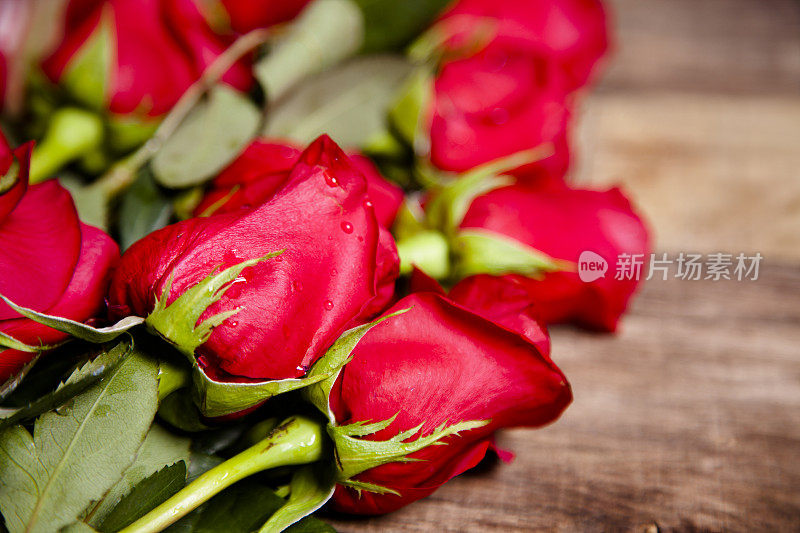 情人节快乐。特写镜头。红玫瑰花束。乡村的木桌上。