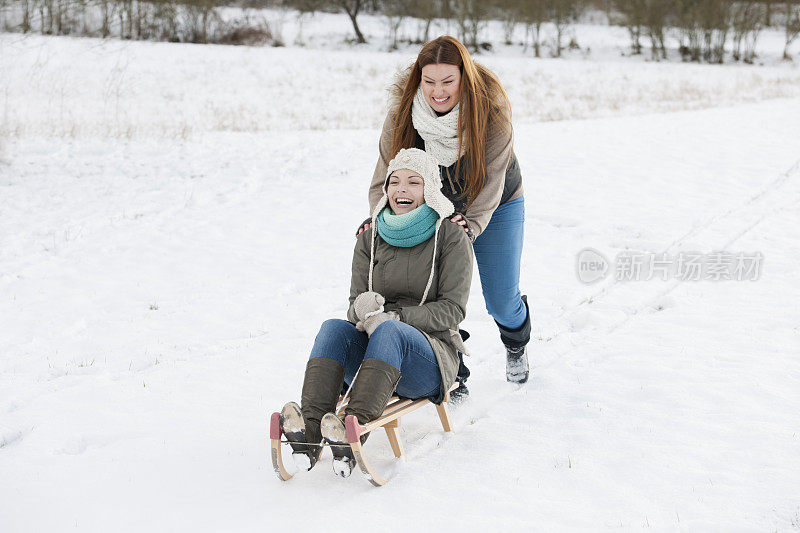 两个女人在雪地里滑着