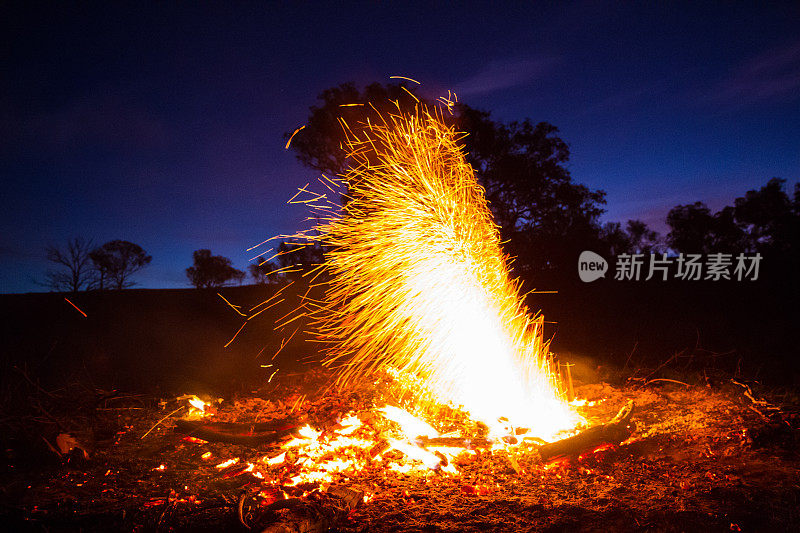 一个明亮的橙色火柱从篝火中爆炸出来