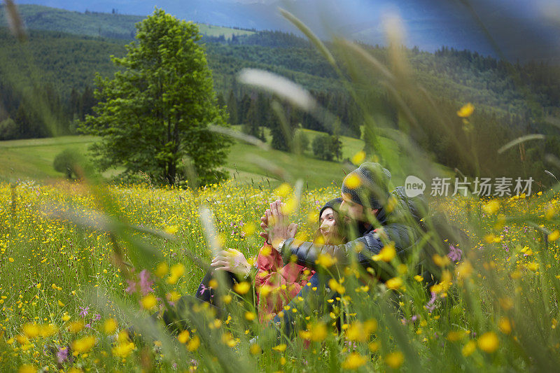 青年男女躺在草地上。拥抱大自然。山