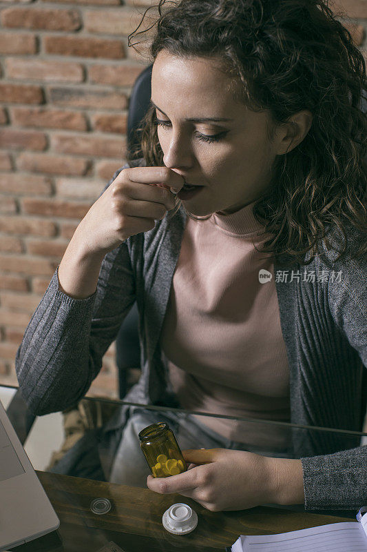 正在服用药片的女商人