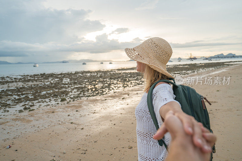 跟随我的概念-年轻女子带领男子到热带海滩