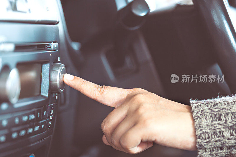 女人开车时用手打开收音机