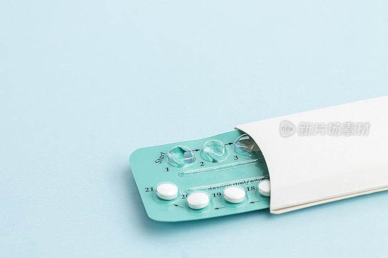 蓝色背景上的避孕药。生育控制