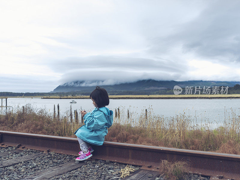 亚洲小孩坐在火车上玩手机