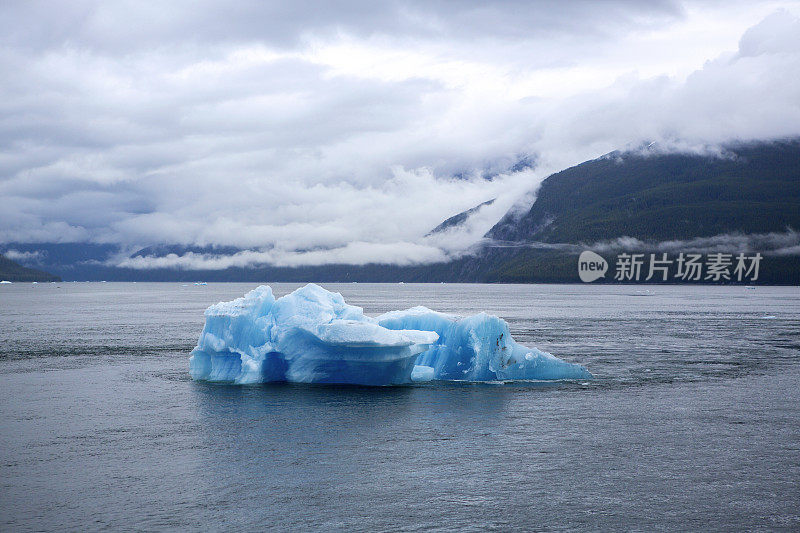 蓝色冰山漂浮在多山的海湾