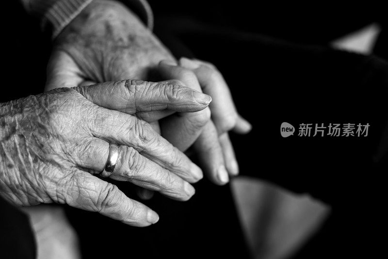 老妇人握着年轻人的手