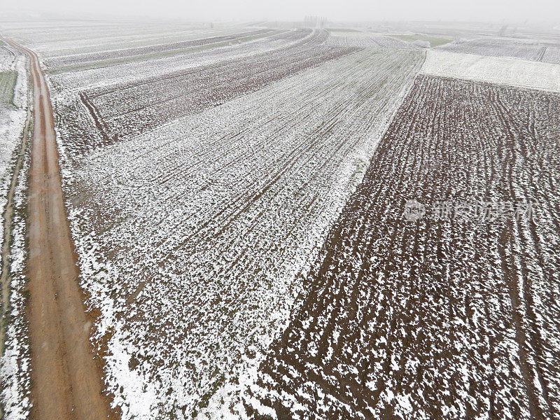 早春时节，山谷里的农田覆盖着一层薄薄的雪。鸟瞰图。