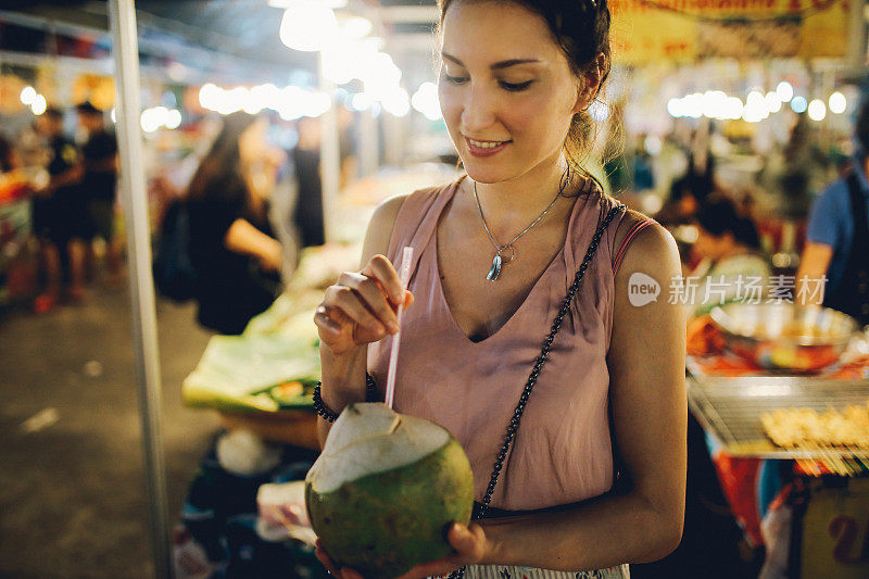 泰国街头小吃-年轻女子有一个美味和新鲜的椰子汁在路上