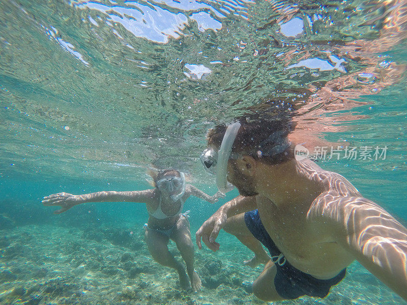 年轻夫妇在水下自拍，度假夏天的概念