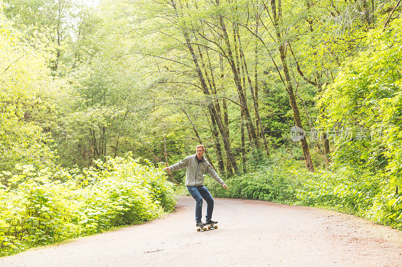 一位红头发的千禧一代在森林小径上玩滑板