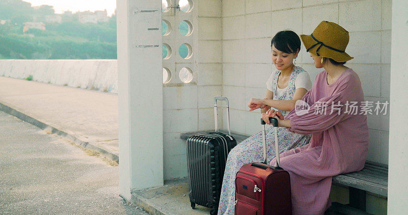 两个女人在等公共汽车。