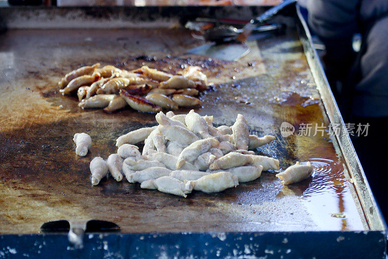 鸡皮煎饺-鸡皮包裹的饺子，在横滨的食品摊上，在烹饪前后的图片