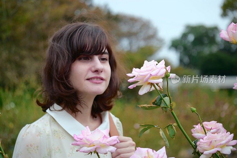 美丽的女人欣赏花园