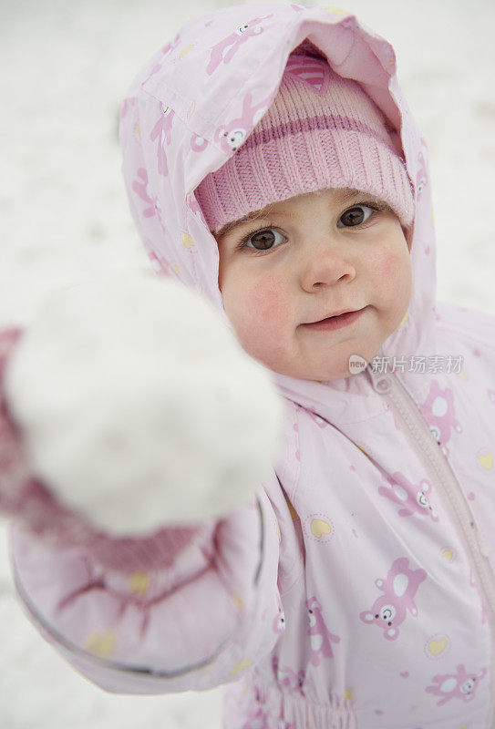 正面的金发小女孩玩雪雪球