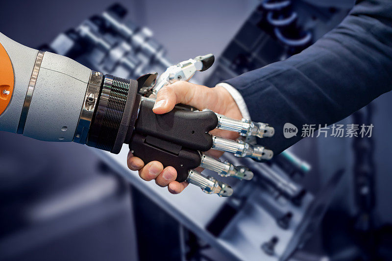一个商人和一个机器人握手的手。