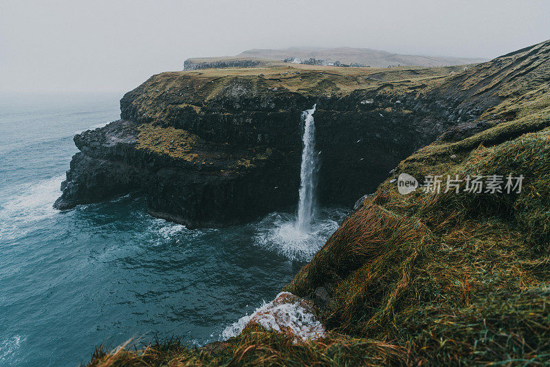 在法罗群岛的风景Múlafossur瀑布坠入大海