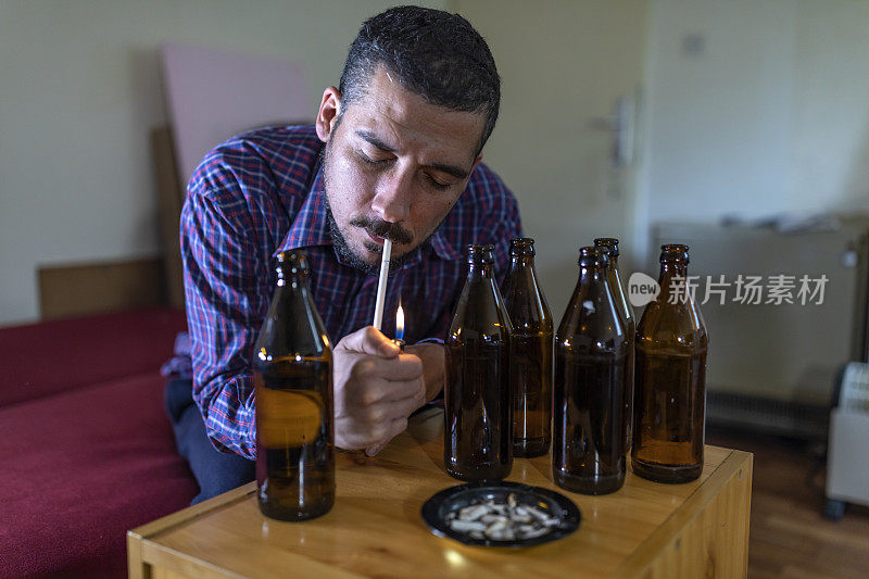 年轻悲伤的醉酒男子喝啤酒和酒精感到浪费，孤独和绝望的痛苦和情绪压力。人与酗酒、上瘾和男人抑郁的概念。