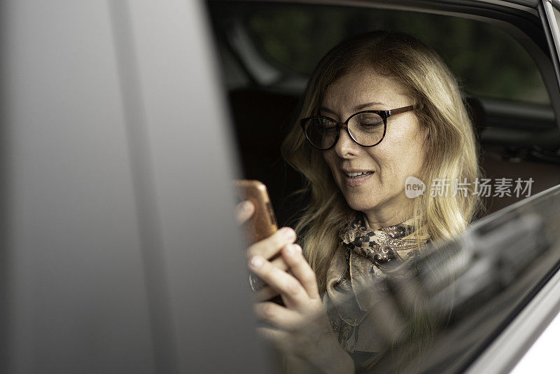 在出租车里用手机的女人