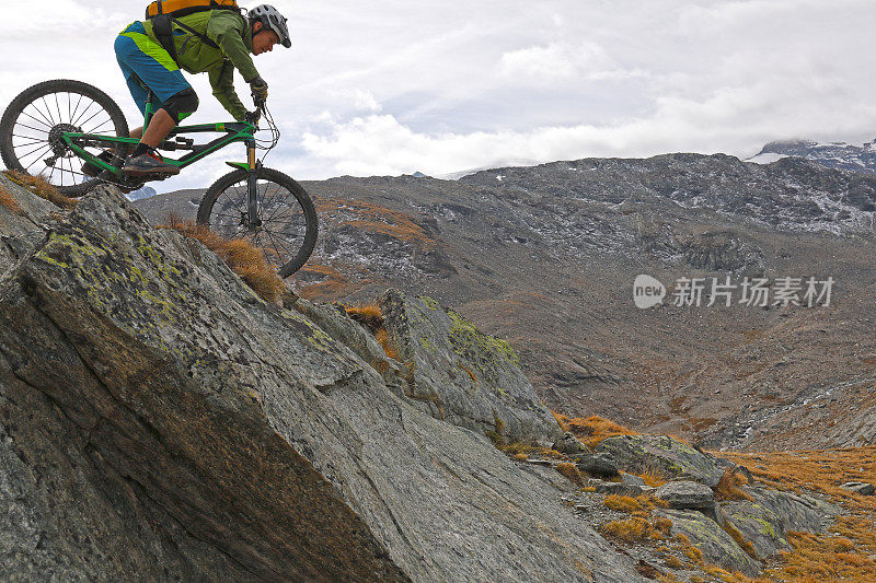 山地自行车手骑下马特洪山下面的岩石板