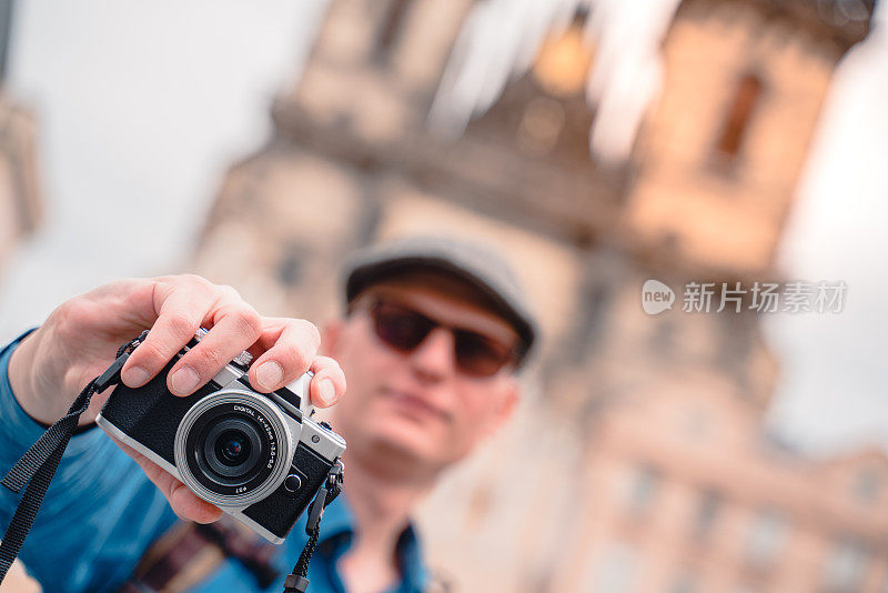 布拉格老市政厅塔，一位摄影师拿着手机在Týn前的圣母教堂前拍照