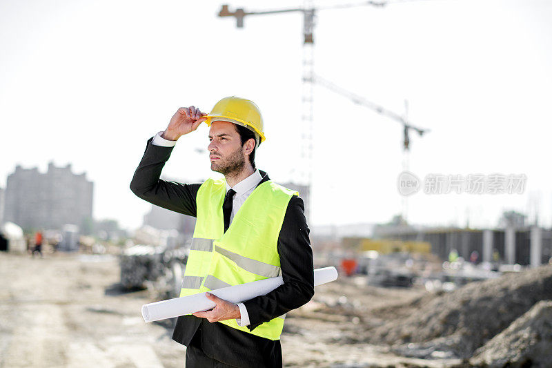 专业工程师建筑工人戴安全帽和图纸施工现场