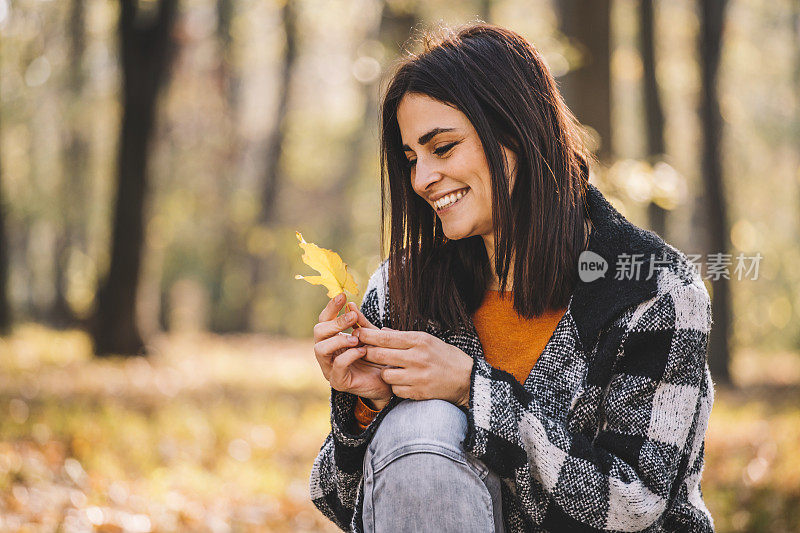 快乐的女人在森林里享受美丽的秋日