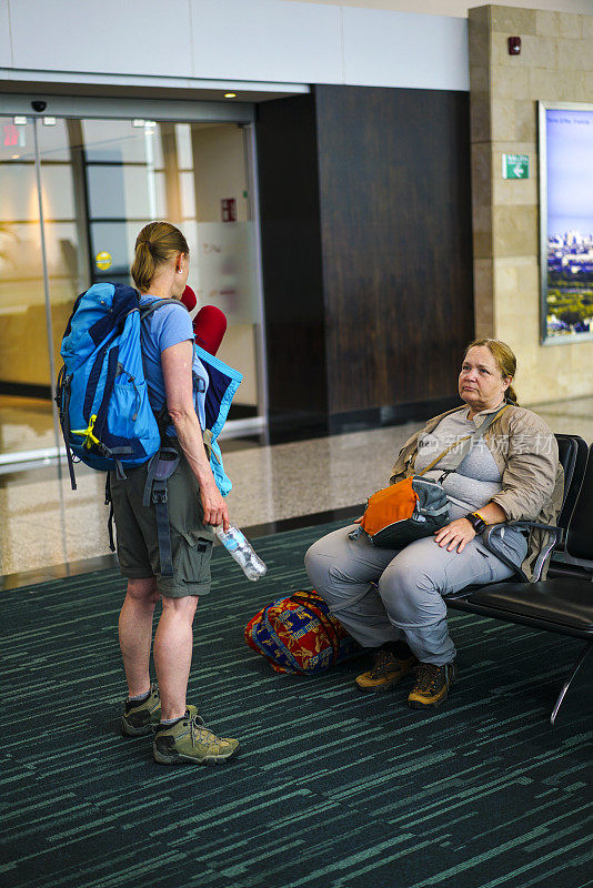 两位年长的女士在机场候机时交谈
