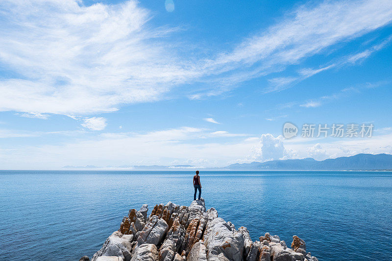 女游客欣赏着大海的景色