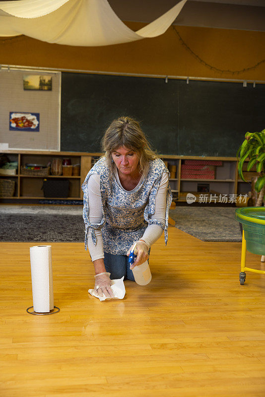 一位老师正在清理教室里溢出的水。