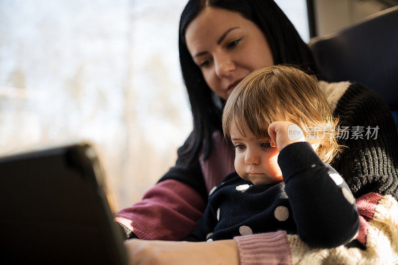 一位年轻的母亲带着她可爱的女儿乘火车旅行，沿途经过美丽的风景