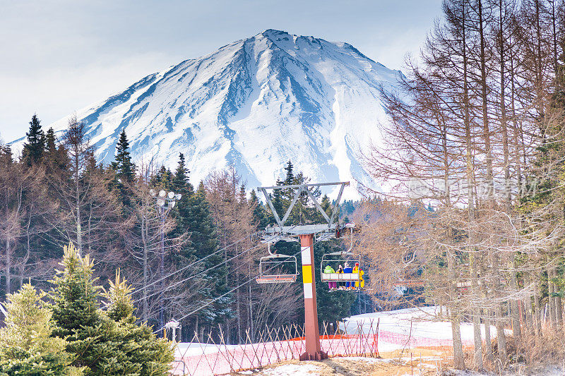 富士山一览无余，游人成群的滑雪胜地，雪谷松树坡，富士山山顶美丽的冬季美景