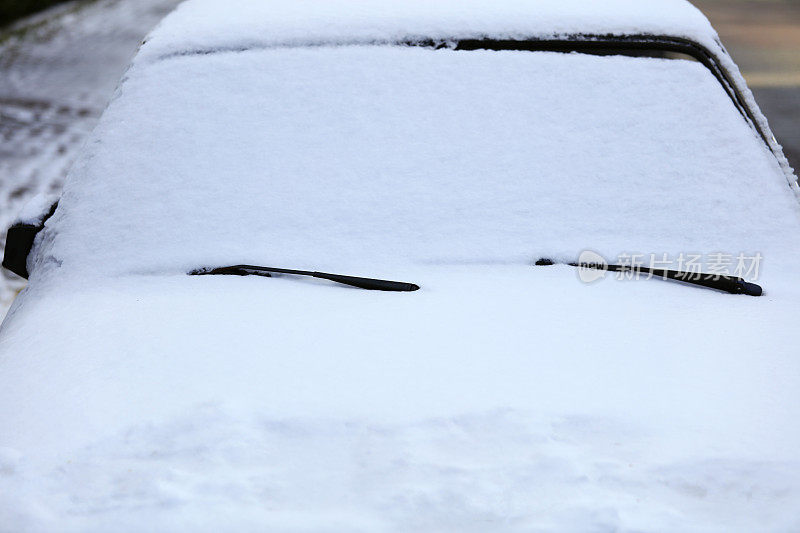 车上的雨刷和挡风玻璃上都被雪覆盖了