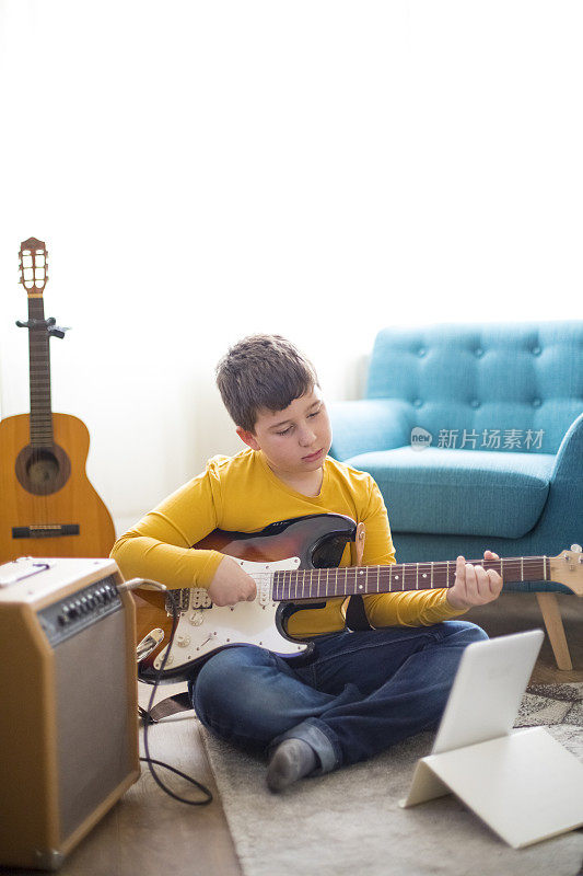 小男孩在家弹电吉他
