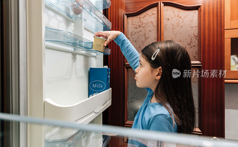 悲伤的女孩从冰箱里拿最后一个酸奶