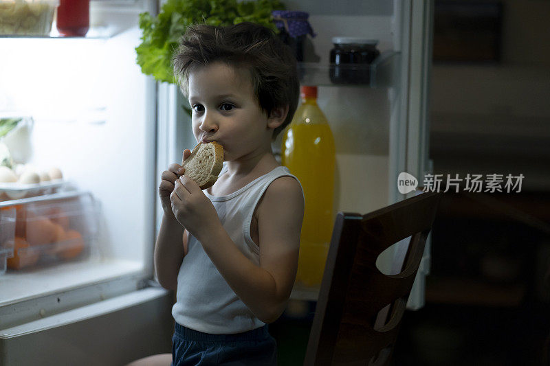 小男孩晚上在冰箱前