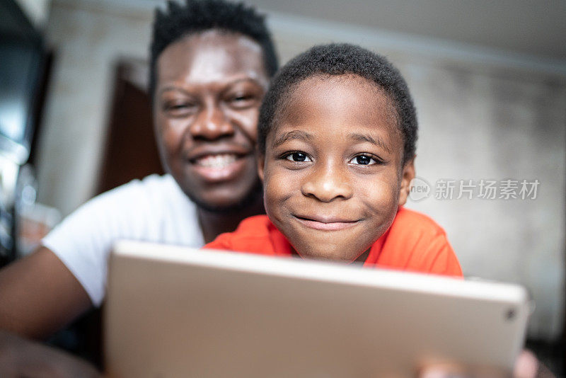 父亲和儿子在家里使用数码平板电脑的肖像