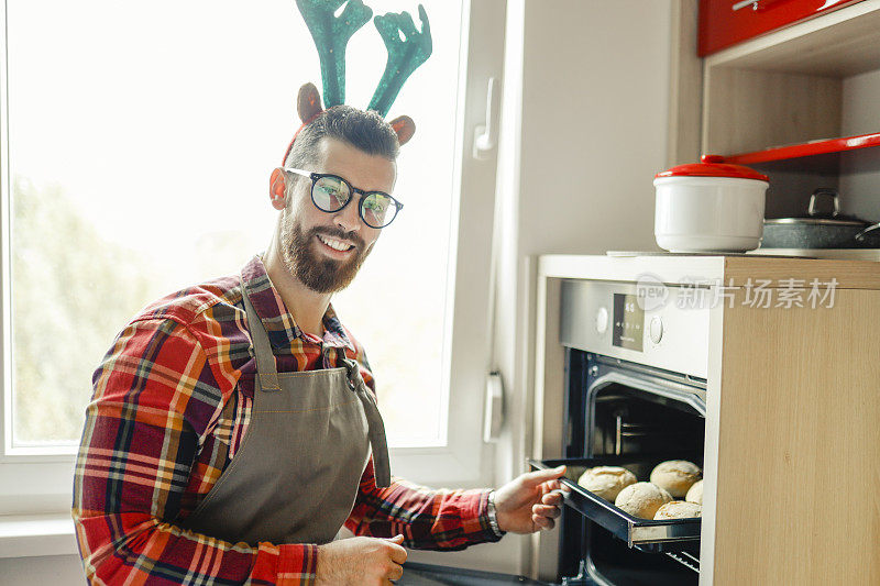 一个年轻人正在烤面包，准备圣诞晚会