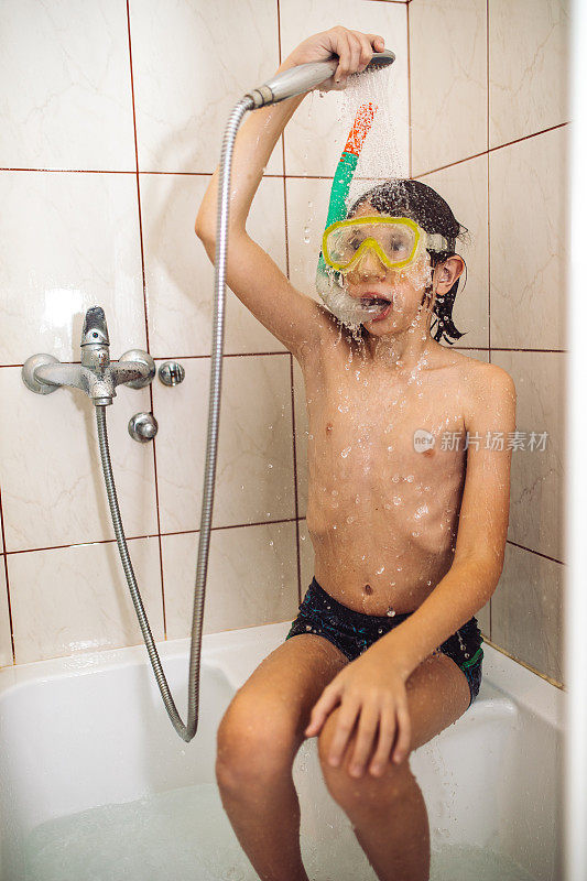 男孩在淋浴下玩耍